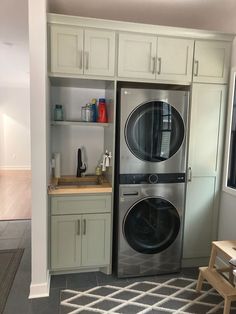 a washer and dryer sitting in a kitchen next to cabinets with doors open