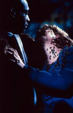 a man and woman dancing together in the dark