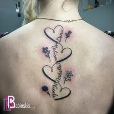 the back of a woman's shoulder with two hearts and flowers on it that says, i love you