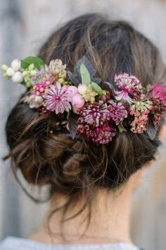 a close up of a woman wearing a flower headpiece with flowers in her hair