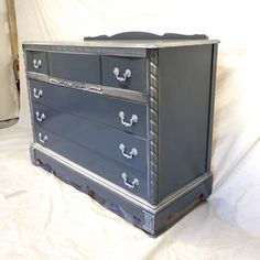 an old dresser is painted blue and silver