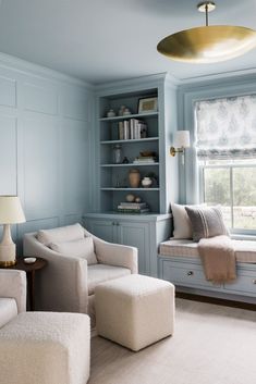 a living room with blue walls and white furniture