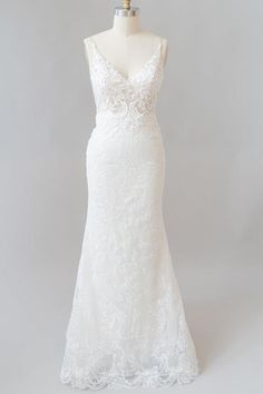 a white wedding dress on a mannequin with an open back and lace detailing