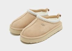 Slip them into premium style with these children's Tazz from UGG. In a Sand colourway, these downsized slippers have a smooth suede upper and an ultra-lush UGGplush lining and insole for moisture-wicking comfort. They're sat above a soft EVA midsole and a sugarcane EVA outsole for extra height and grip. Finished off with UGGbraid detailing on the collar, a woven heel pull and the UGG badge. Ugg Slippers For Kids, Cute Shoes Uggs, Uh Slippers, Small Uggs, Ugg Slippers Aesthetic, Sand Uggs, Beige Uggs, Uggs For Kids, Uggs Tazz