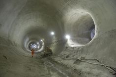 two men are standing in the middle of a large tunnel with light at the end