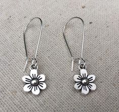 These are just so sweet and cute!  Little daisy dangle earrings.  Perfect addition to any outfit and sure to brighten your day!Made from allergy free plated silver.  The flowers measure 1/2” long by 3/8” wide and hang from 1” kidney style ear wires that lock and latch.  Overall drop length is 1 1/2”.  Thanks for stopping by!  Please take a moment and visit the rest of my Etsy shop.  I have many more unique jewelry designs to choose from!🌸 Tiger Flower Jewelry 🌸  🌸 Inspired by Nature 🌸 Whimsical Spring Earrings With Flower Charm, Whimsical Spring Flower Earrings With Ear Wire, Hypoallergenic Dangle Earrings For Spring, Hypoallergenic Spring Dangle Earrings, Spring Flower Earrings With Ear Wire, Cute Flower-shaped Pierced Earrings, Spring Nickel Free Drop Flower Earrings, Cute Spring Earrings With Ear Wire, Nickel-free Flower Earrings For Spring