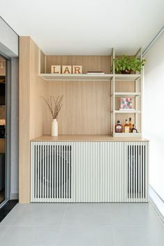 a room that has some shelves on the wall and a plant in front of it