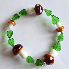 a bracelet with green, white and brown beaded glass beads on it's sides