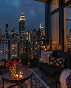 a living room filled with furniture and a view of the empire building at night in new york city