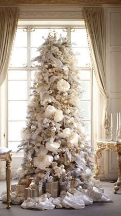 a white christmas tree with presents under it