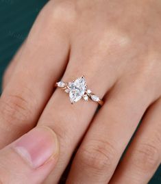 a woman's hand with a diamond ring on top of her finger and an engagement band