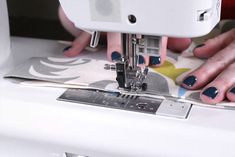 a woman is using a sewing machine to sew on her hand and foot nails