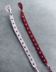 two pieces of red and white rope with hearts on them sitting next to each other