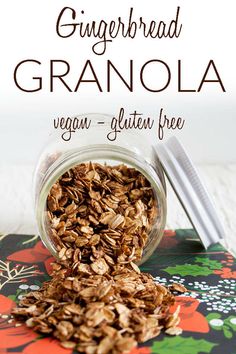 a jar filled with granola sitting on top of a floral table cloth next to a spoon