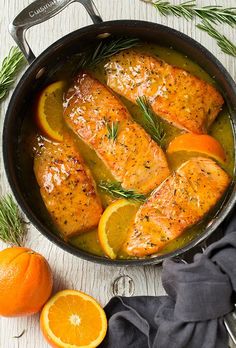 salmon with oranges and rosemary in a skillet