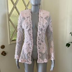 Lovely and versatile sheer pale pink mesh jacket with lace appliques' and scattered clear rhinestones. Long sleeves, open front, hip length. Has shoulder pads which can be easily removed. Measurements are 34" bust, 29" waist, 42" hips, 26" length, 24" sleeve length; this can fit a size small to medium due to the open front. Glam up a sweet little slip dress or toss over a tank top and jeans for a more casual look! Very good vintage condition. Sheer Long Sleeve Party Outerwear, Fitted Spring Outerwear With Sheer Sleeves, Spring Fitted Outerwear With Sheer Sleeves, Spring Sheer Party Outerwear, Spring Party Sheer Outerwear, Sheer Outerwear For Spring Party, Fitted Long Sleeve Outerwear With Lace Patchwork, Spring Outerwear With Lace Patchwork And Long Sleeves, Fitted Lace Patchwork Outerwear For Spring