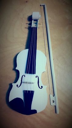 a white violin sitting on top of a wooden table