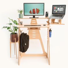 a laptop computer sitting on top of a wooden desk next to a monitor and keyboard