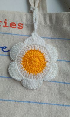 a crocheted flower is attached to a bag with the word articles written on it