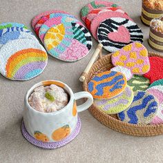 colorful coasters and cups on the floor next to each other with cookies in them