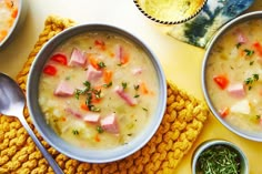 two bowls filled with soup on top of a yellow cloth next to silver spoons