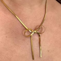 Unleash your wild side with the Lily Bow Necklace. This unique snake chain necklace features a playful, feminine bow design that will add a touch of quirkiness to any outfit. Perfect for the fashion-forward trendsetter, this necklace is sure to make a statement. 18k Gold Plated Over Stainless Steel Hypoallergenic Water & Tarnish Resistant Adjustable Necklace With Decorative Bow For Party, Chic Herringbone Necklace With Adjustable Chain, Chic Metal Jewelry With Bow Detail, Dainty Snake Chain Necklace For Party, Chic Jewelry With Butterfly Knot For Parties, Chic Adjustable Jewelry With Bow Detail, Chic Adjustable Jewelry With Bow, Chic Delicate Chain Herringbone Necklace As Gift, Chic Party Jewelry With Butterfly Knot