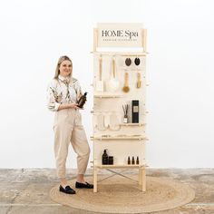 a woman standing in front of a display case with bottles and utensils on it