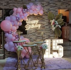 a birthday party setup with balloons and tables in front of a sign that says happy birthday