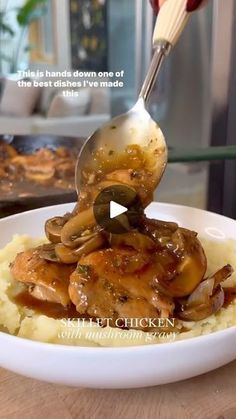 a person is spooning some food on top of mashed potatoes with mushrooms and onions