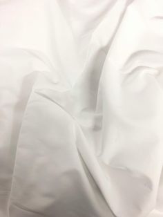 an unmade bed with white sheets and pillows