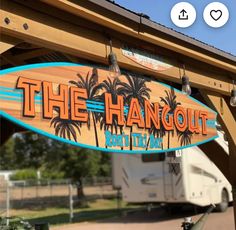 the hangout sign is attached to a wooden structure with an rv in the background