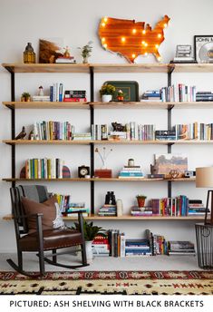 a living room filled with lots of furniture and bookshelves next to a rug