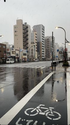 a bike lane on a rainy day with buildings in the background