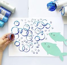 someone is making an art project with watercolors on paper and glue for the fish