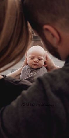 a man holding a baby up to his face with the caption's name on it