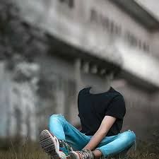 a person sitting on the ground with their legs crossed in front of an old building