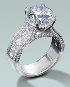 a diamond ring with two rows of diamonds on the band and an oval shaped center stone