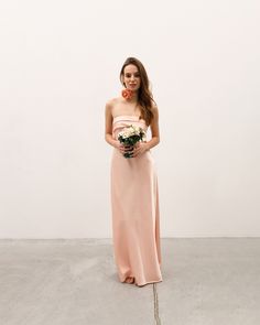 a woman in a pink dress holding a bouquet