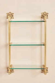 a gold shelf with glass shelves on it