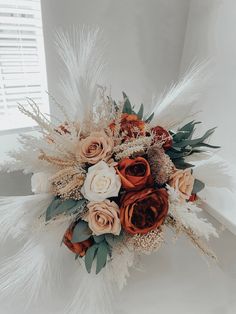 a bridal bouquet with feathers and flowers