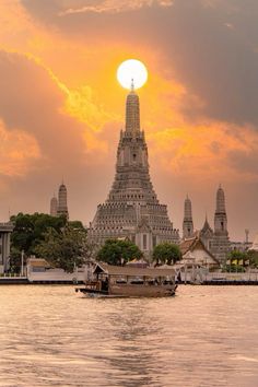 the sun is setting in front of an ornate building with spires on each side