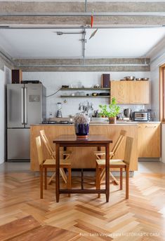 a kitchen and dining room with wooden floors, cabinets, appliances and an open floor plan