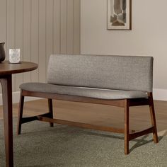 a wooden bench sitting on top of a carpeted floor next to a coffee table