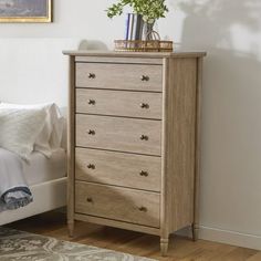 a bedroom scene with focus on the chest of drawers and a bed in the background