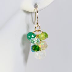 Organic style colorful cluster earrings with gems in different shades of green. They are made with smooth polished and faceted, various size roundels of chrysoprase, peridot, chrome diopside, green onyx, lemon and blue topaz, Ethiopian opal, apatite and rainbow moonstone. All of the gems are wrapped on gold filled head pins and arranged into pretty clusters swinging beneath simple gold filled ear wires. 1.25 inches top to bottom Thank you for looking! Please contact me if you have any questions Green Gemstone Round Bead Earrings, Green Gemstone Earrings With Round Beads, Green Multi-stone Drop Earrings, Green Faceted Round Earrings, Green Round Faceted Earrings, Green Teardrop Earrings With Faceted Beads, Green Multi-stone Earrings For Gift, Green Multi-stone Dangle Jewelry, Green Faceted Earrings For May Birthstone