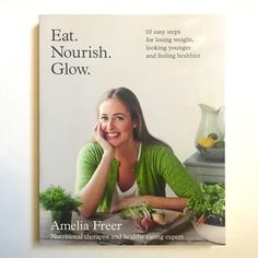 a woman sitting at a table with vegetables in front of her and the words eat nourish glow