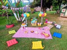 a picnic is set up in the yard with balloons, cake and other food items