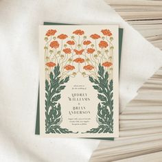 an orange and green floral wedding card on top of a white napkin with the words happily wed