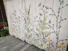 the wall is painted with flowers and plants on it's sides, along with other wood planks