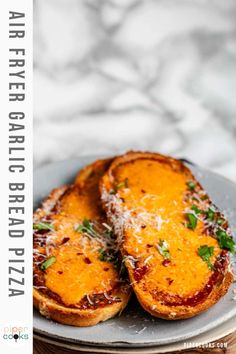 two pieces of bread on a plate with parmesan cheese and herbs sprinkled on top